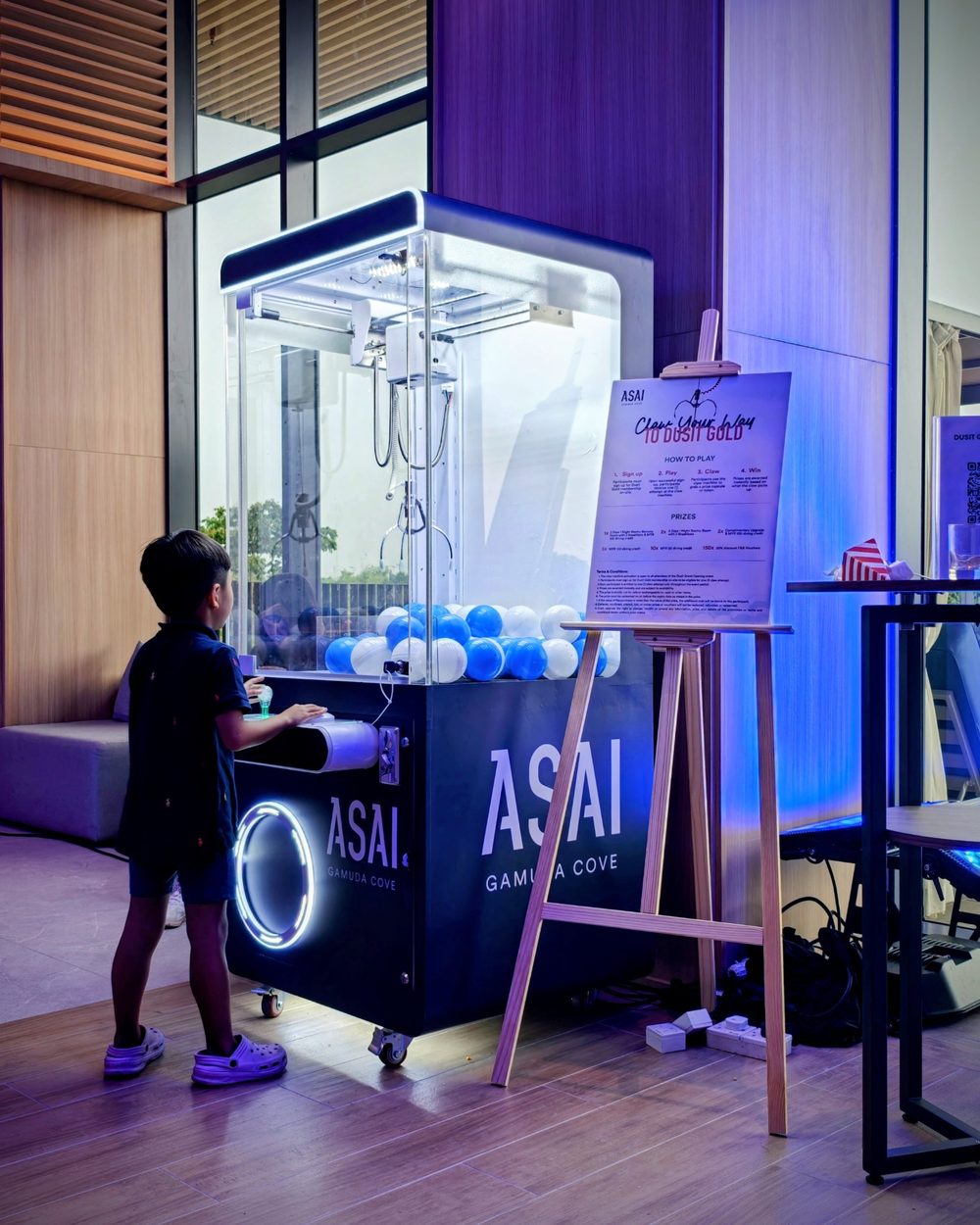 ASAIのロゴが入ったクレーンゲームで遊ぶ子ども