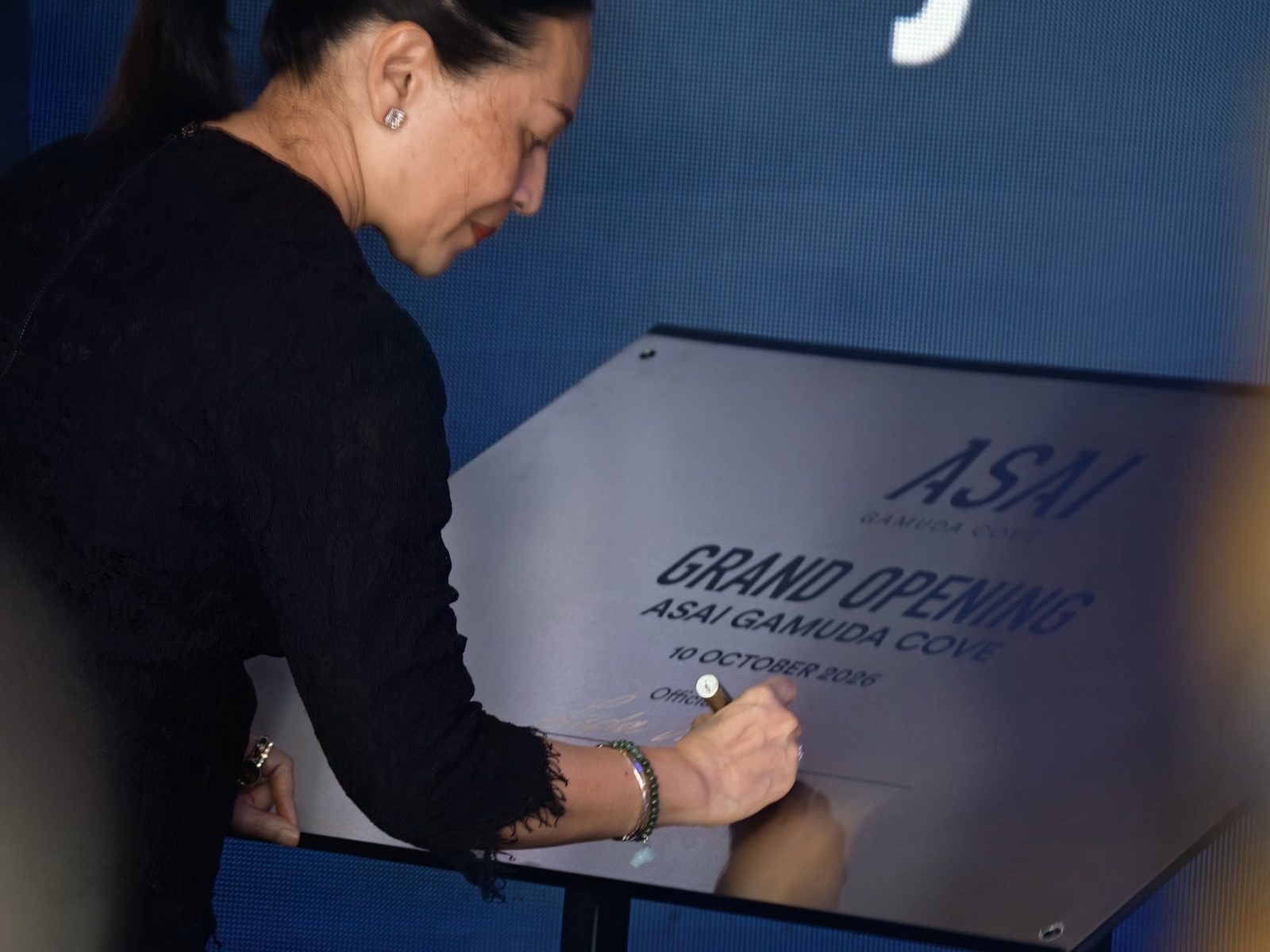 「GRAND OPENING ASAI GAMUDA COVE 10 OCTOBER 2026」と刻まれた記念プレートに署名する来賓