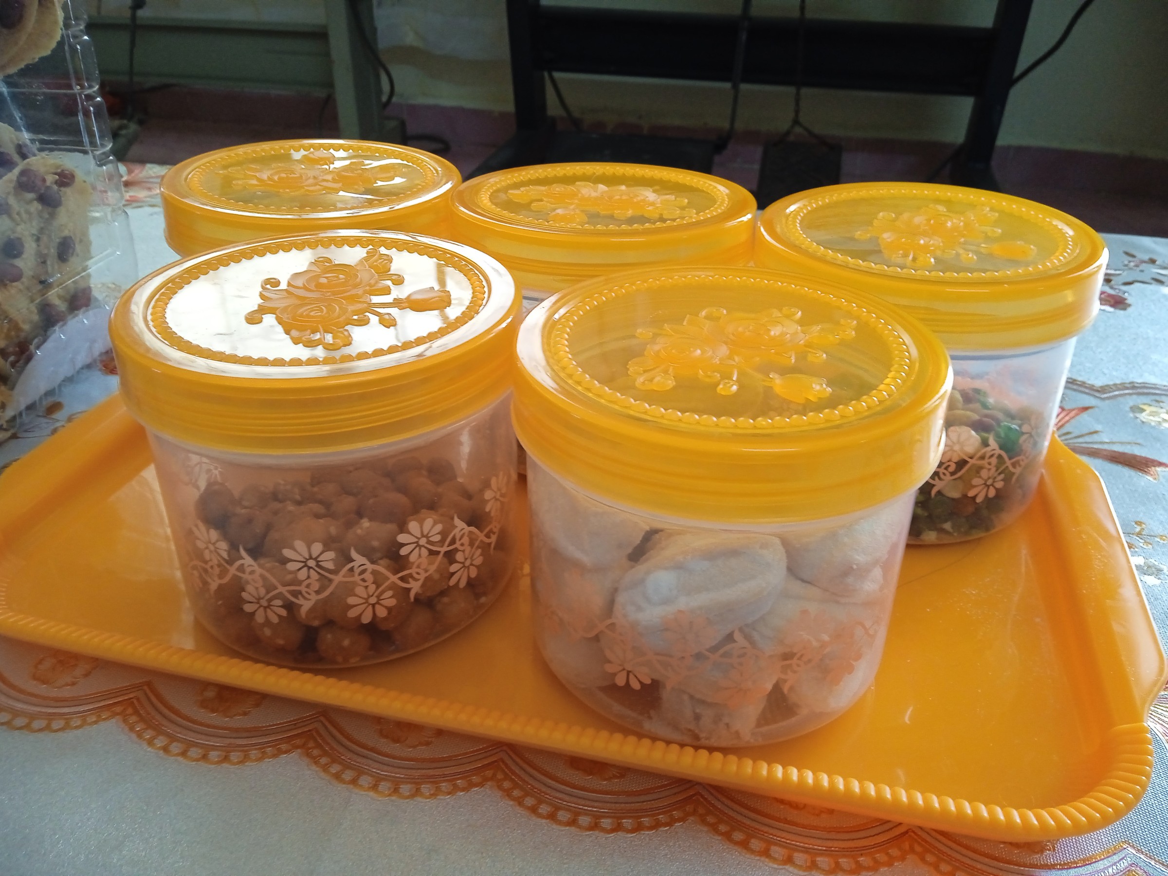 黄色い蓋のプラスチック瓶に入った、色々なラヤ菓子