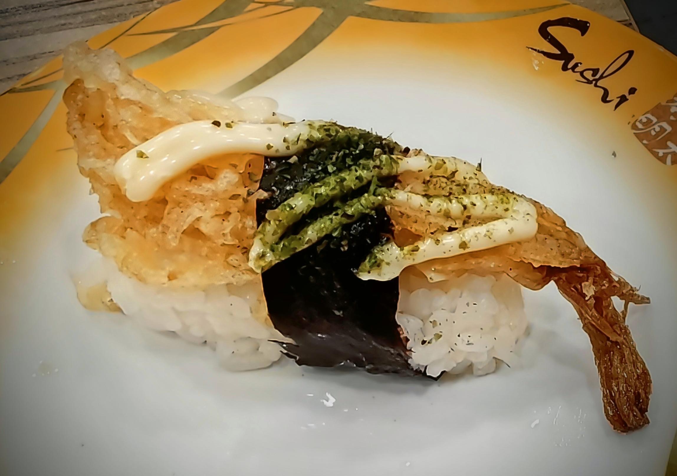 Prawn tempura nigiri held with a band of nori, topped with mayo and aonori