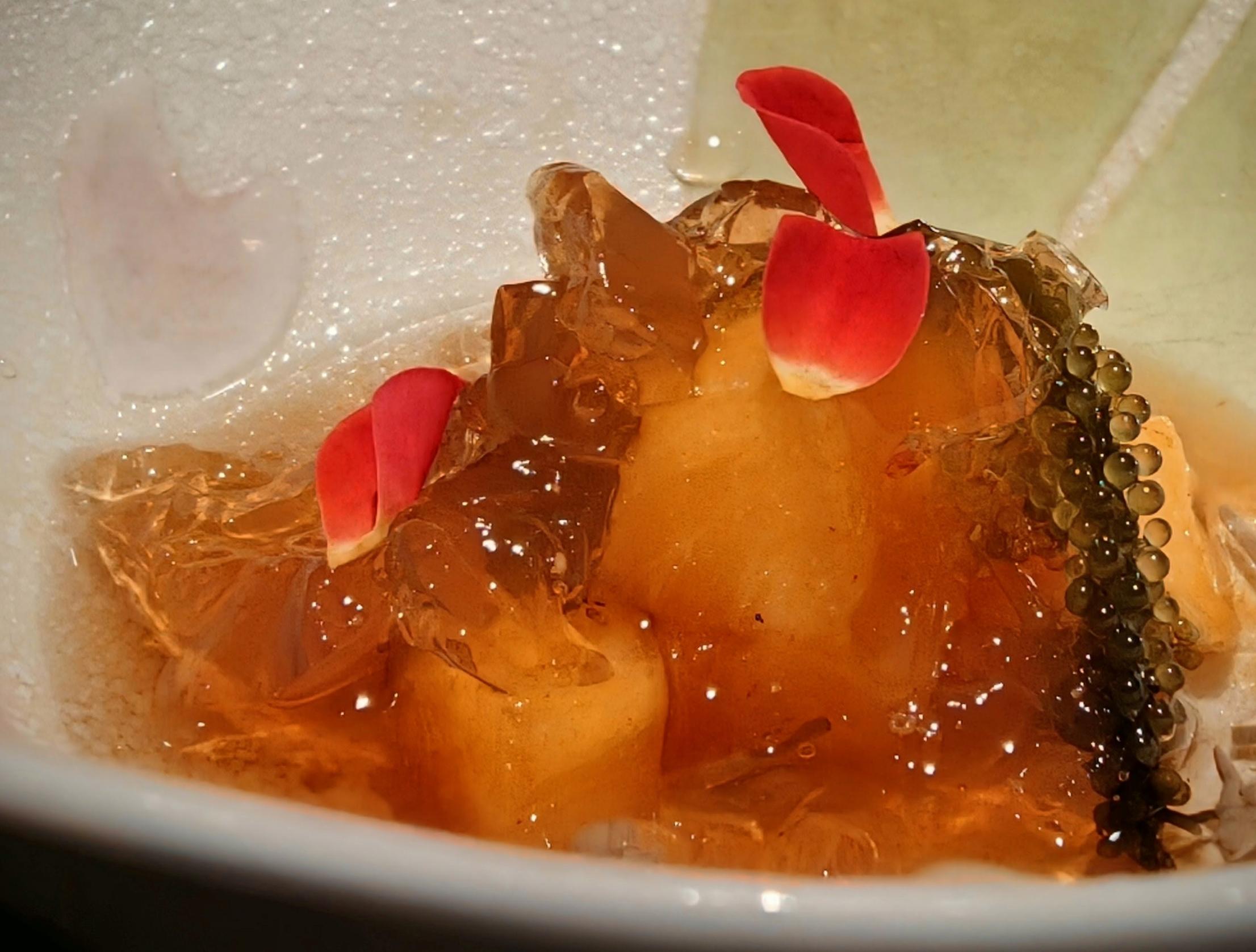 海ぶどうと花びらを添えた、透き通ったジュレの前菜