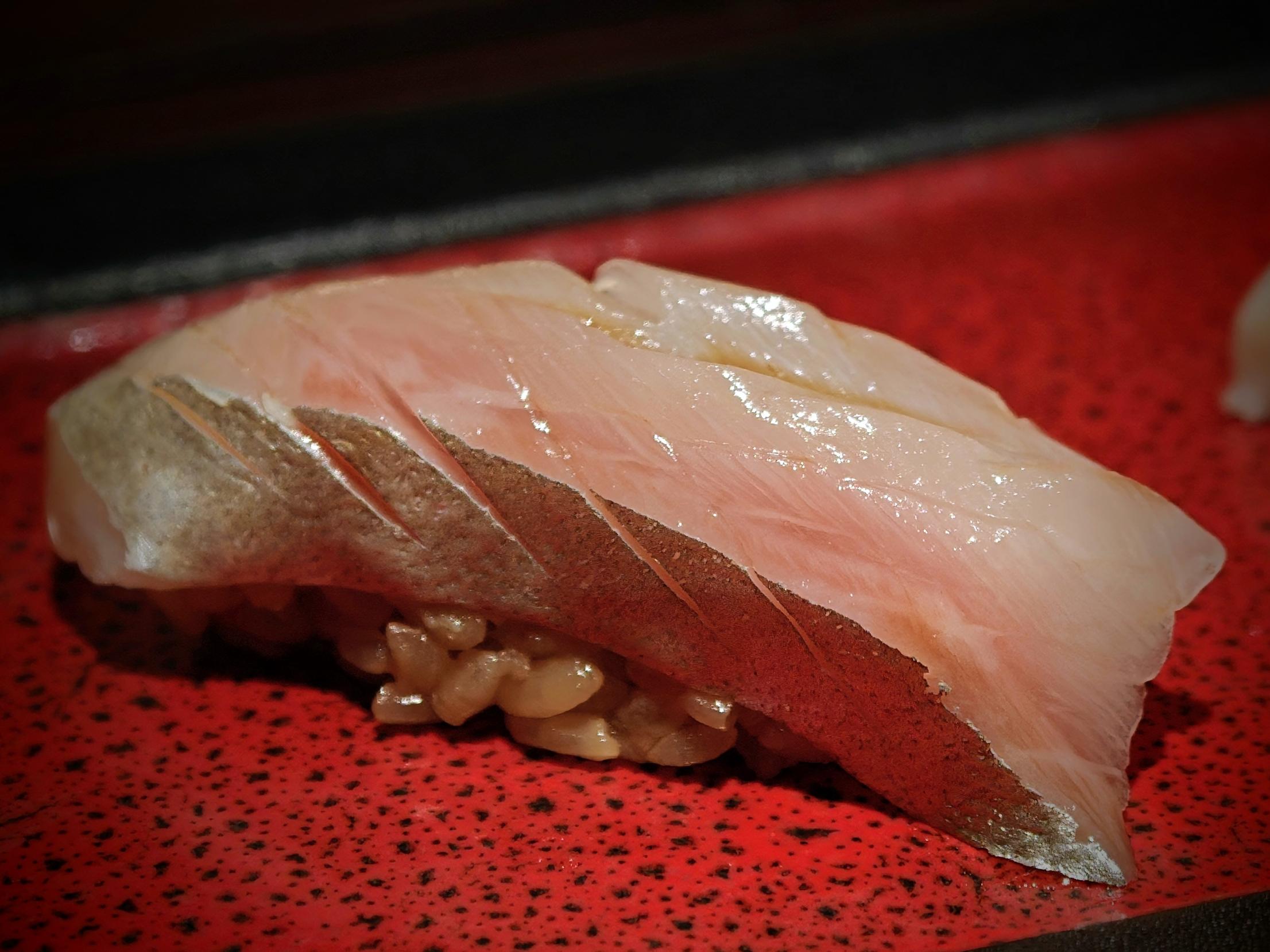 皮目に包丁を入れた光り物の握り。シャリは赤酢