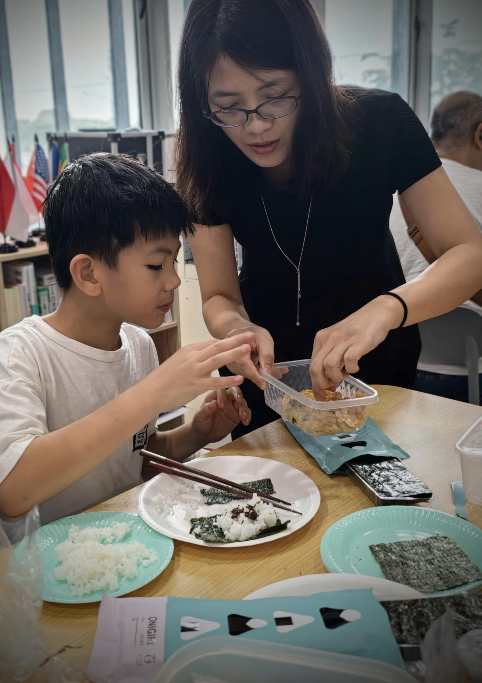 具材を選ぶ男の子と、それを手伝う女性