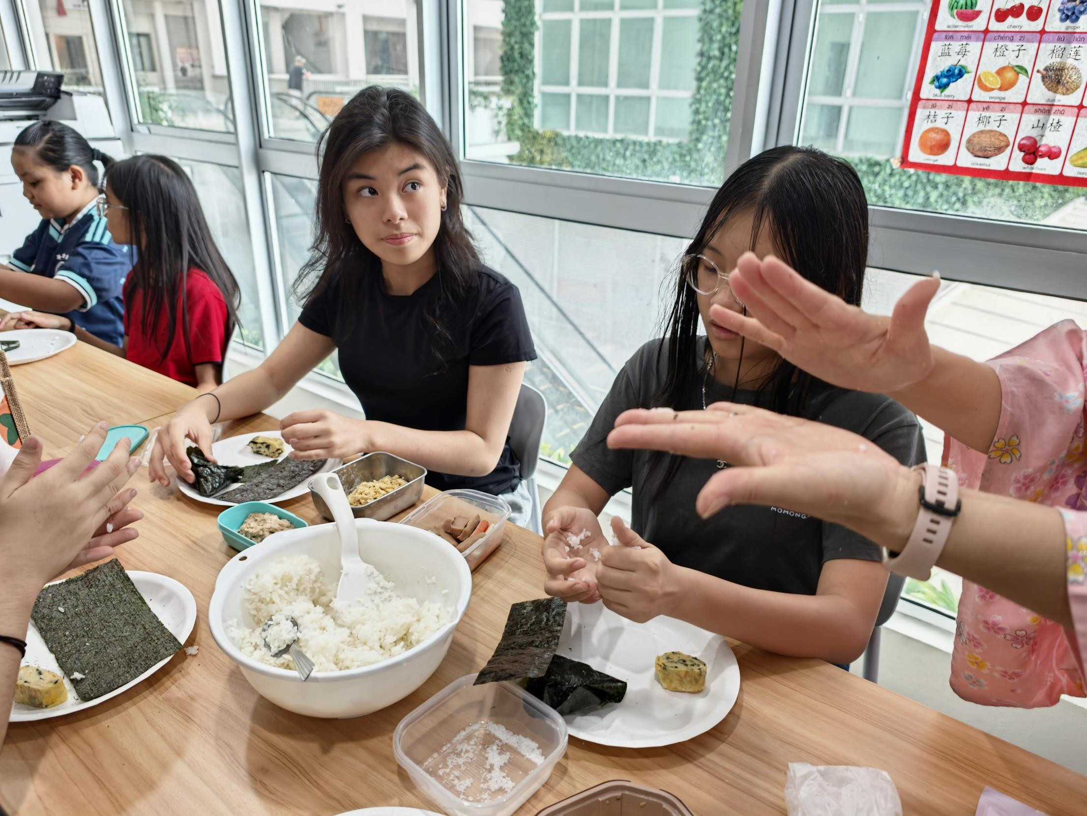 ご飯を手に取り、握り方の説明を聞く参加者